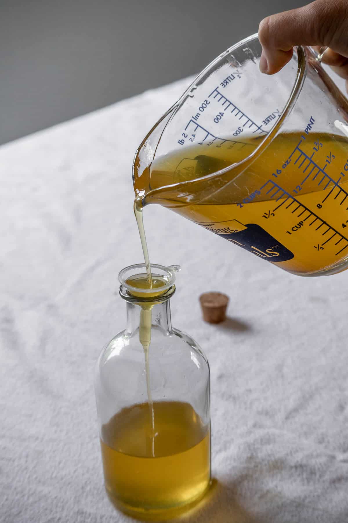 Homemade calendula oil being poured into a bottle