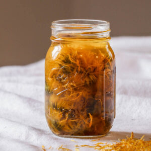 A jar of homemade calendula oil infusing