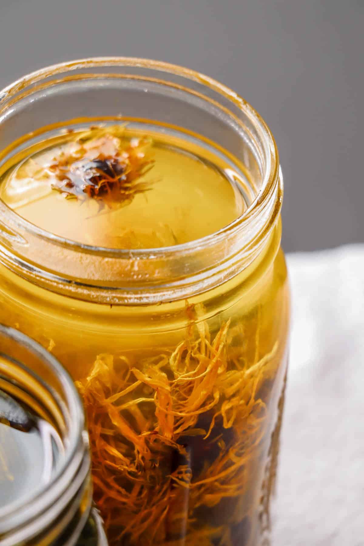 A jar of calendula flowers infusing in oil