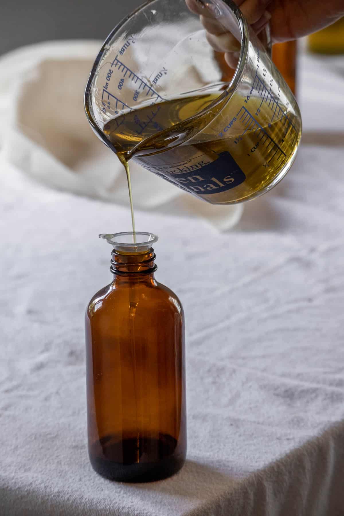 Pouring rosemary oil into an apothecary jar