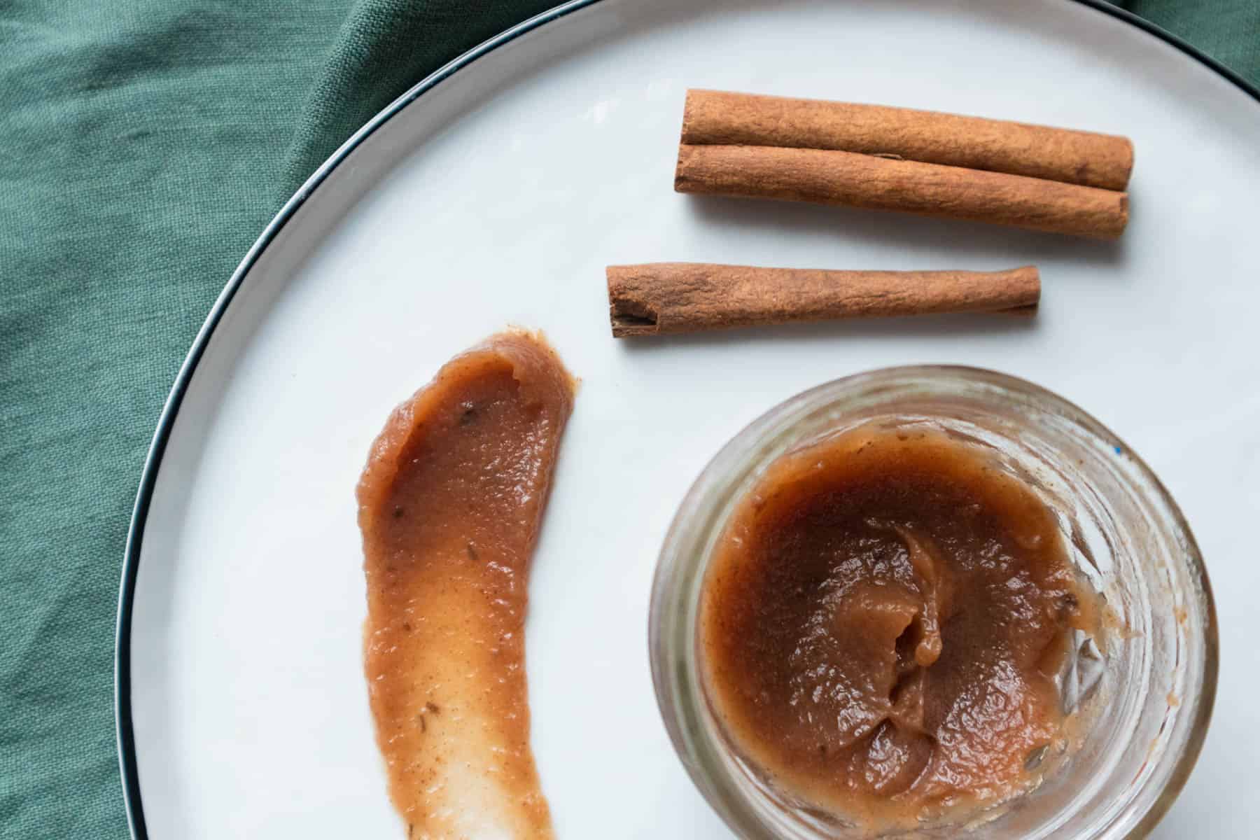 Homemade apple butter spread on a plate with cinnamon